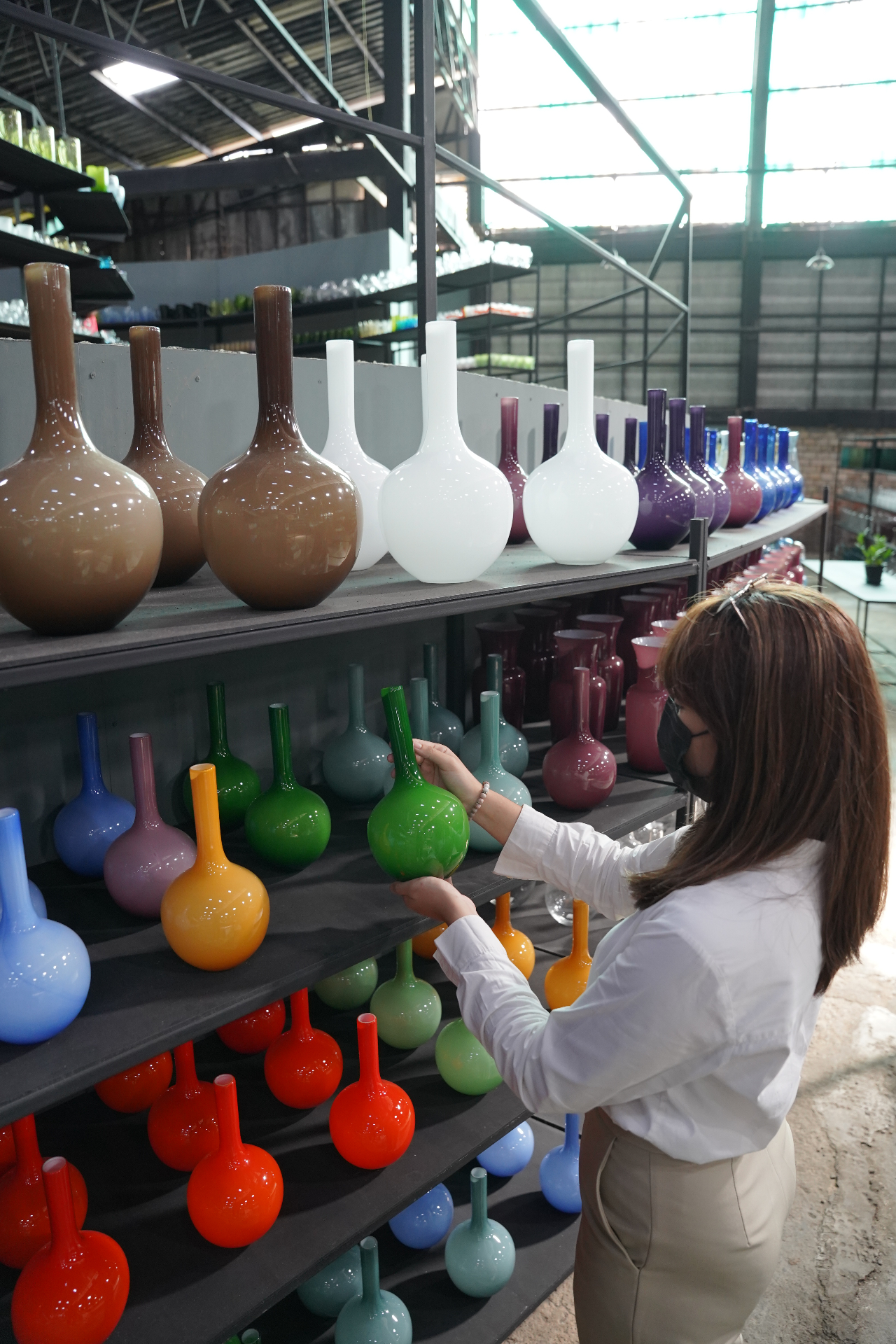 Shelves of pastel-coloured handblown long-neck vases at the Eastern Glass outlet