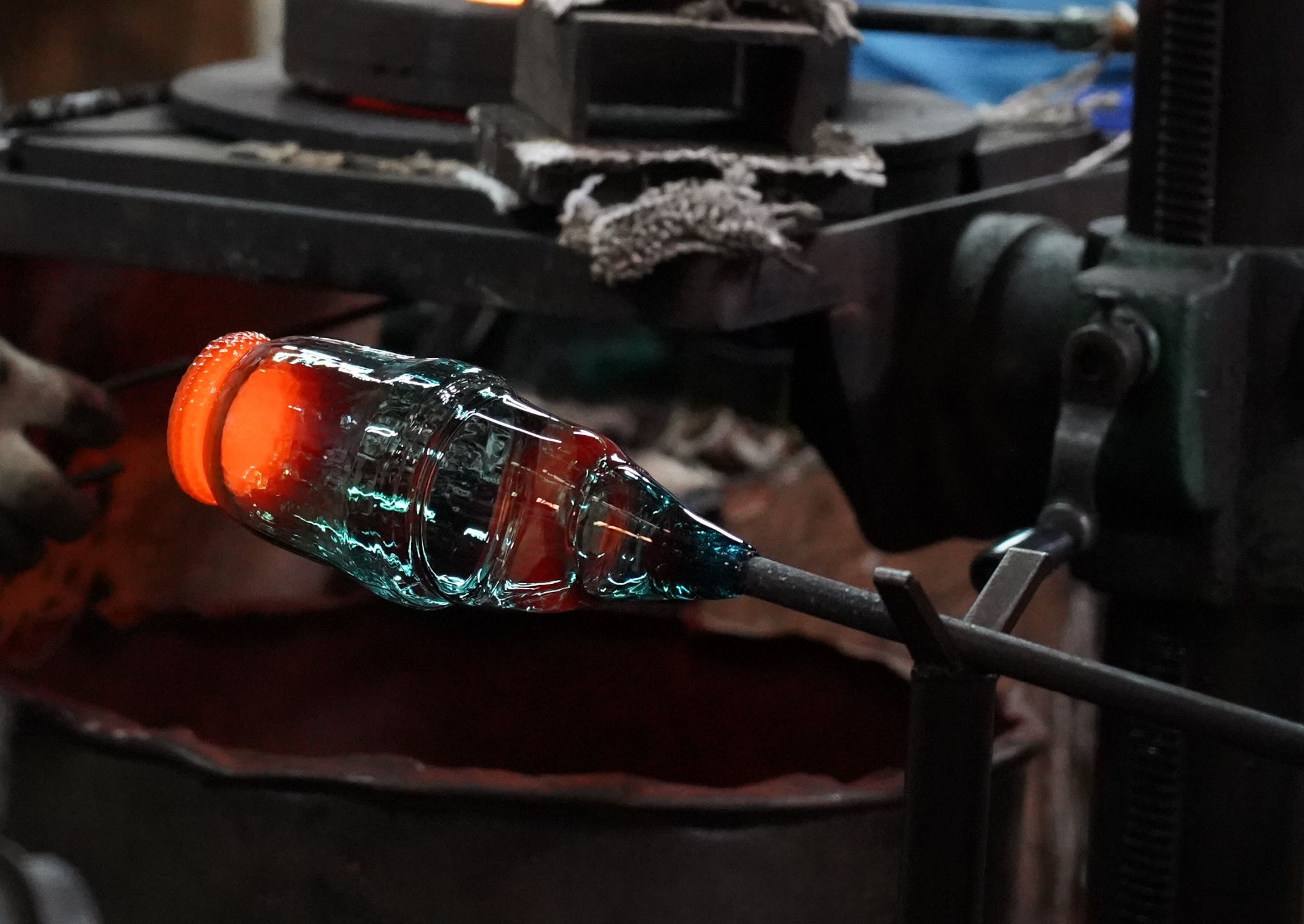 Hot bottle being formed on blowpipe