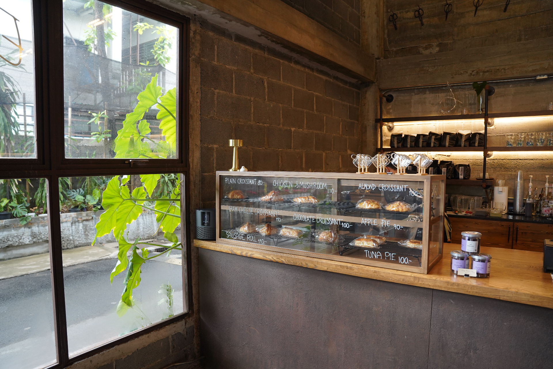 Pastry display case with plain, almond, chicken and chocolate croissants and apple pie