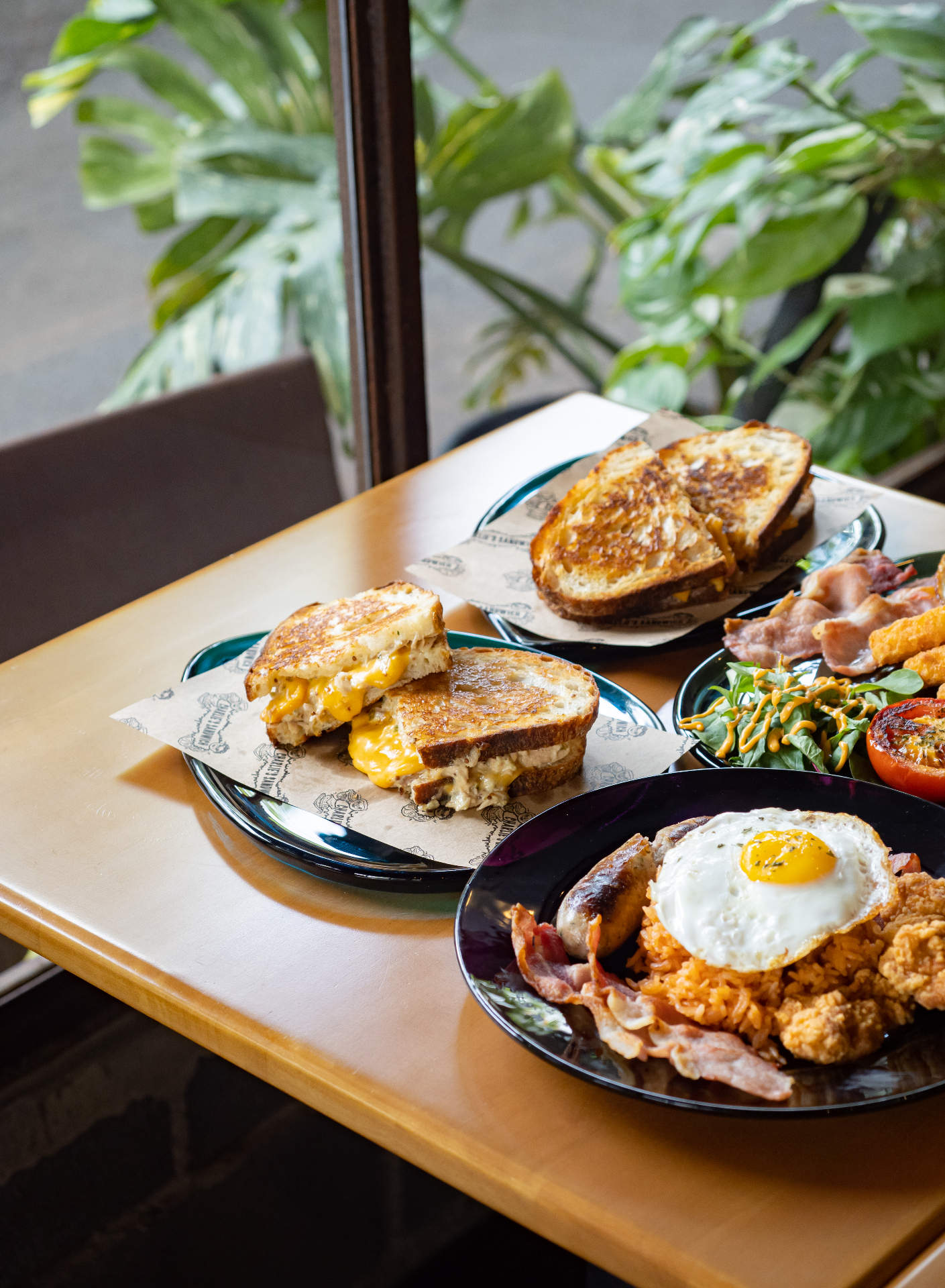 Grilled cheese sandwich, breakfast plate with egg and bacon, and a tuna melt at Eastern Glass café