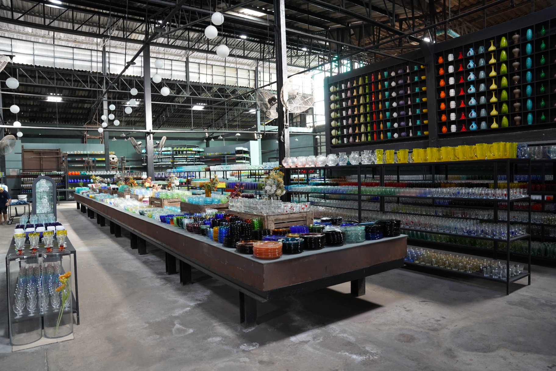 Long communal display table running through the Eastern Glass factory outlet