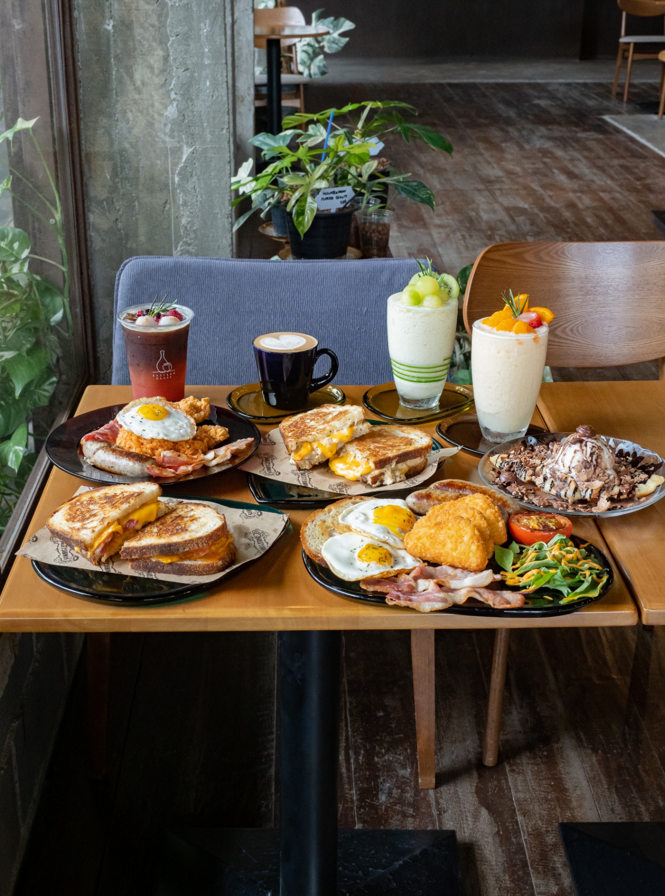 Full brunch spread with iced coffee, latte, smoothies, sandwiches, fried eggs and bacon